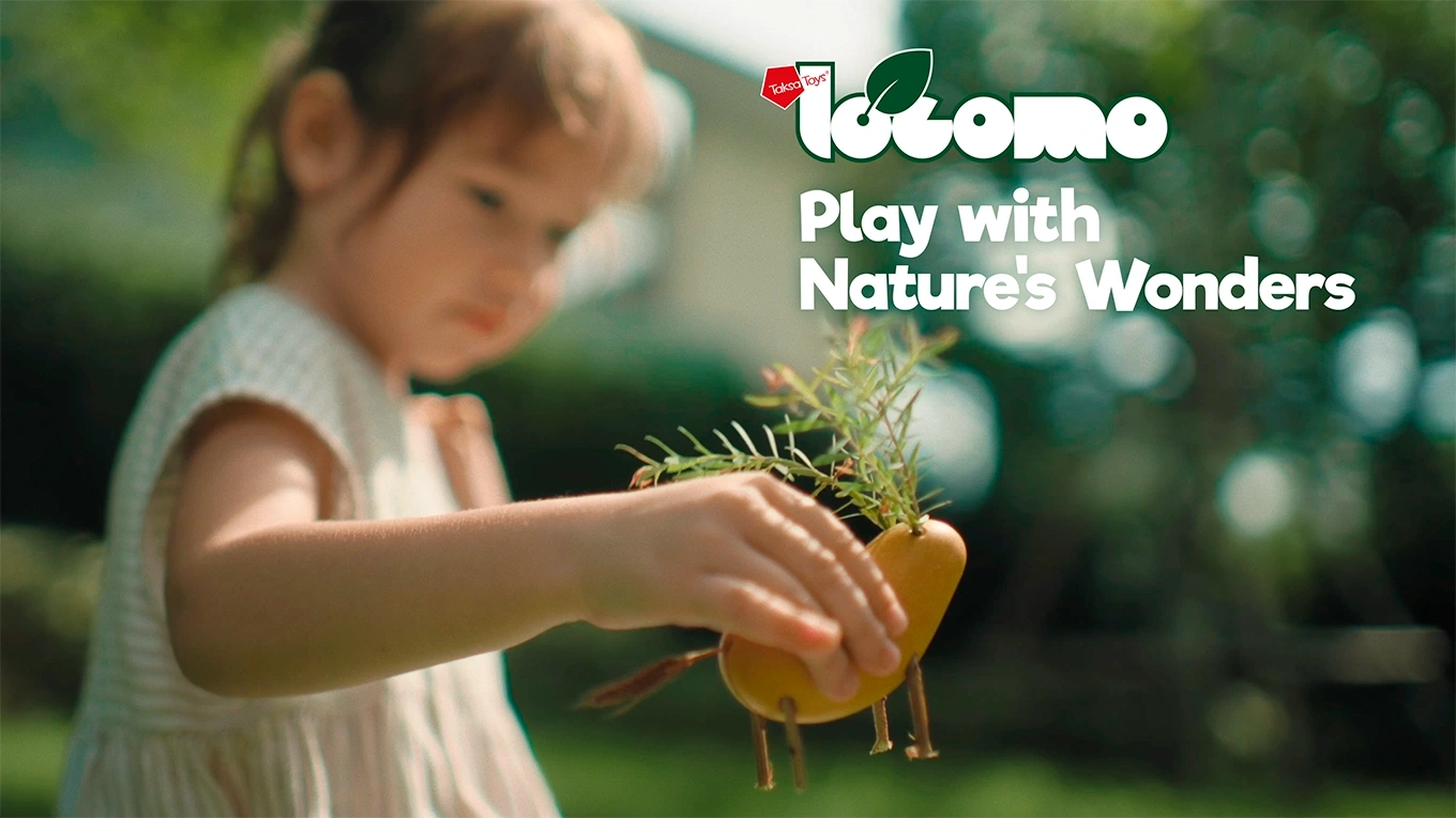 Child creating a character using natural elements with LOCOMO®, exploring nature through observation and imaginative play.